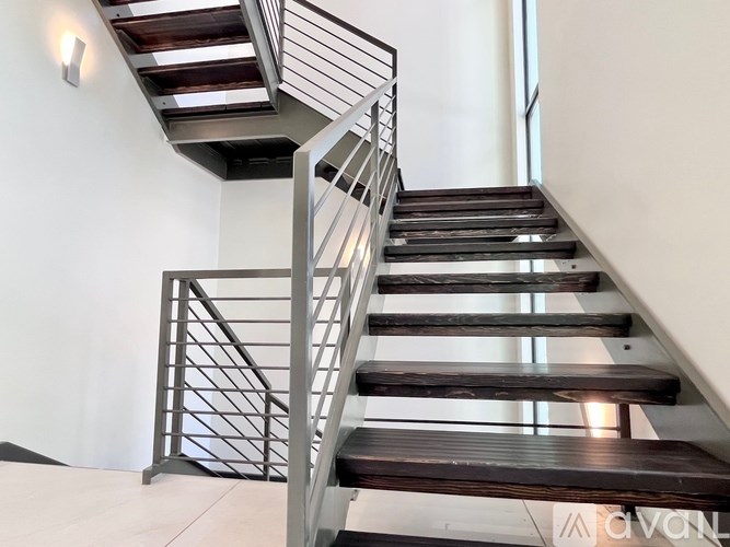 A staircase with a metal railing and wooden steps.
