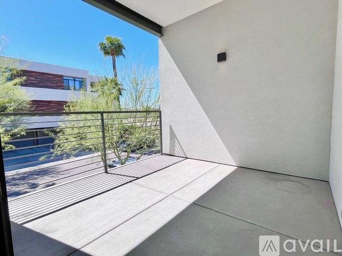 A balcony with a view of a building and a palm tree.