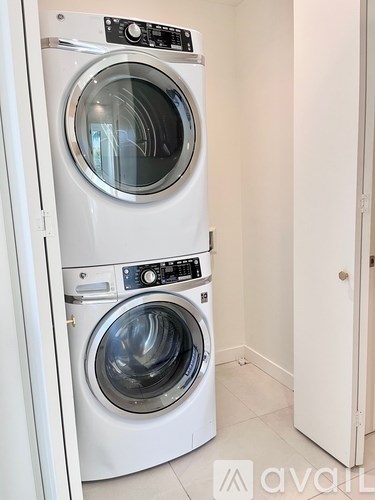 Two front loading washing machines in a small laundry room.