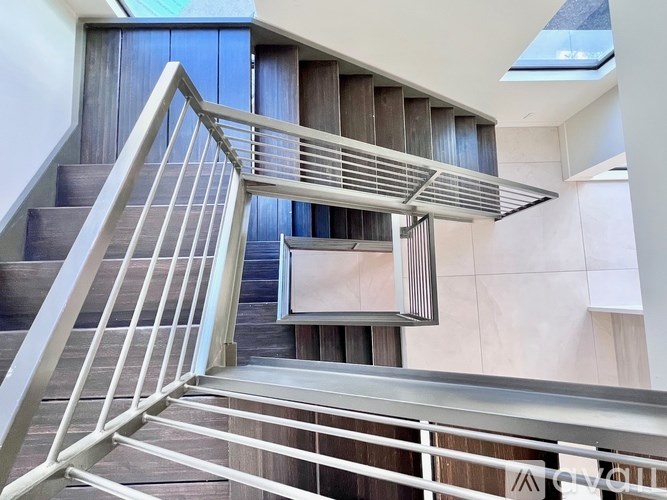 A staircase with a metal railing and wooden steps.