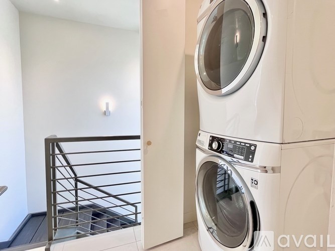 A washing machine is placed in a room with a balcony.