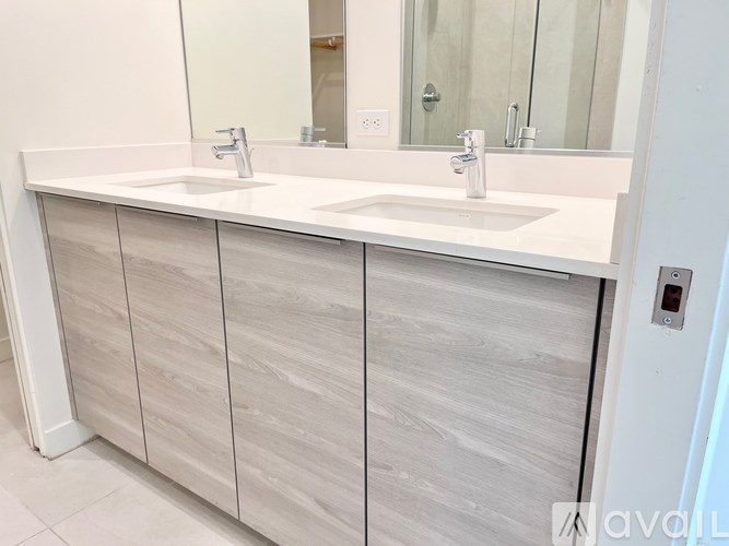 A bathroom with two sinks and a mirror.