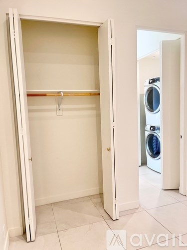 A white dryer is in a white closet.