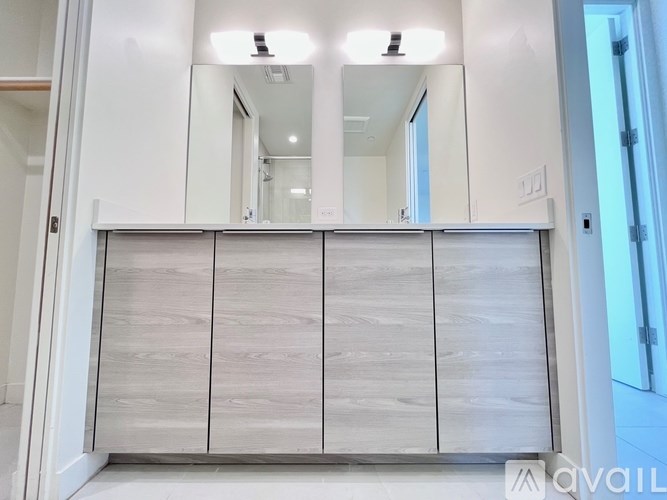 A white cabinet with a mirror above it.