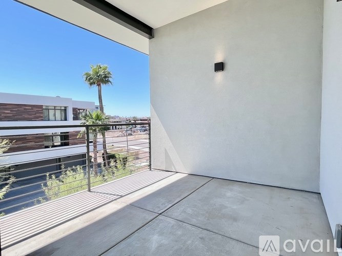 A balcony with a view of a building and a palm tree.