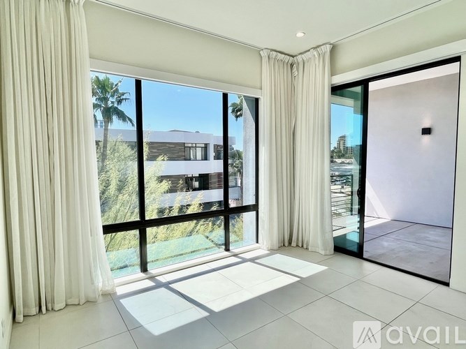 A spacious room with large windows overlooking a lush green landscape.