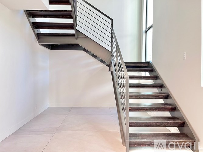 A staircase with a metal railing and wooden steps.