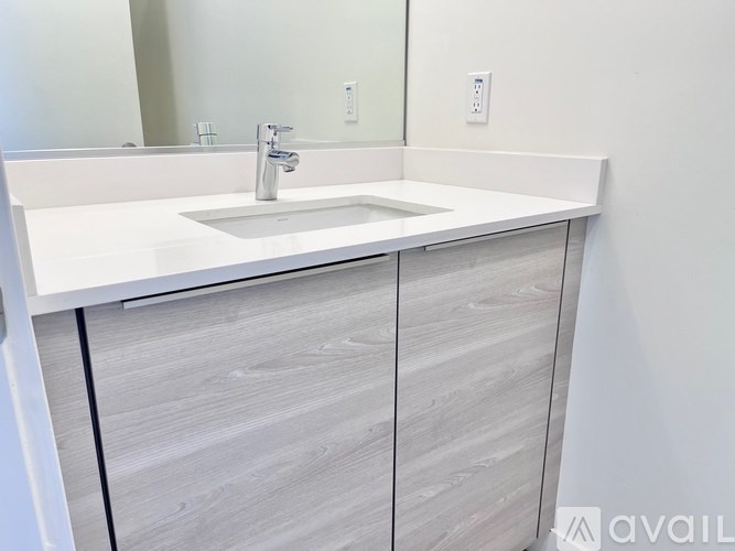 A white sink with a silver faucet is installed in a bathroom.
