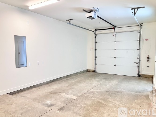 A spacious garage with a white door and a white wall.