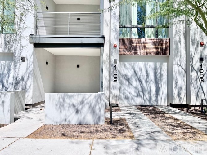 A modern house with a white exterior and a balcony.
