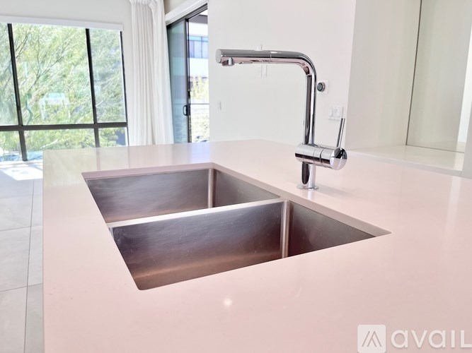 A kitchen sink with a chrome faucet.