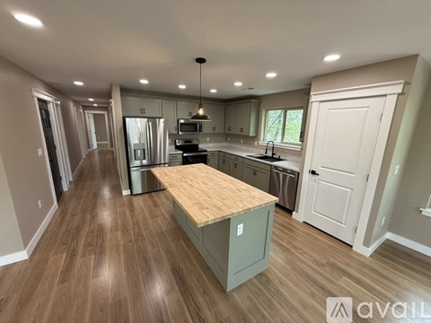 A kitchen with a wooden island in the middle of the room.