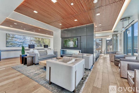A modern living room with a wooden ceiling and a large painting on the wall.