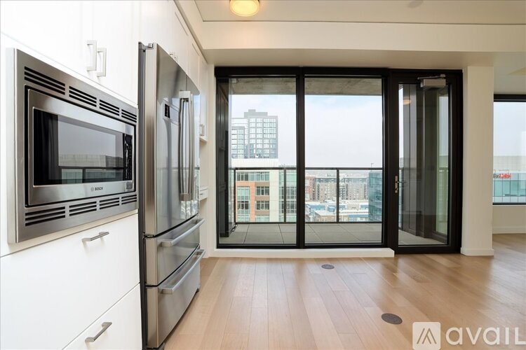 A kitchen with stainless steel appliances and a view of the city.