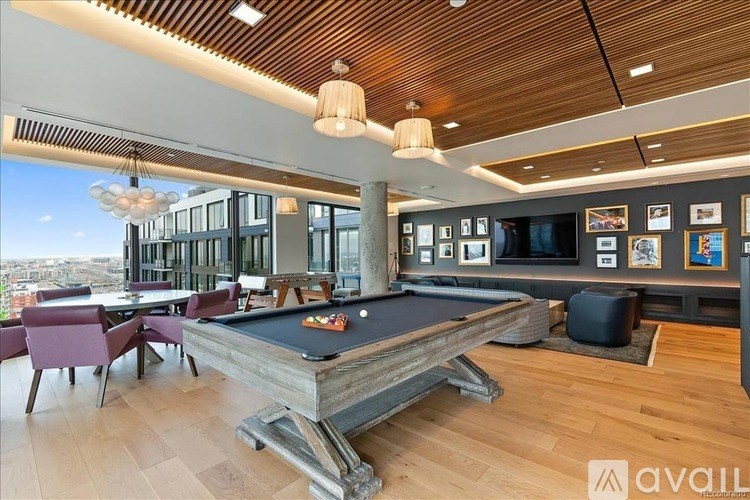 A pool table is in the middle of a room with a view of the city.