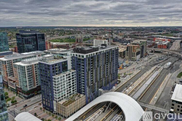 A cityscape with a mix of modern and older buildings, a train track, and a bridge.