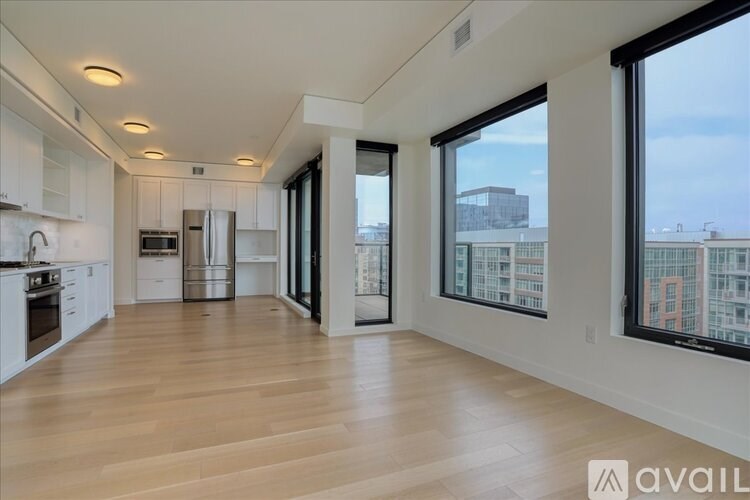 A spacious kitchen with white cabinets and a refrigerator.