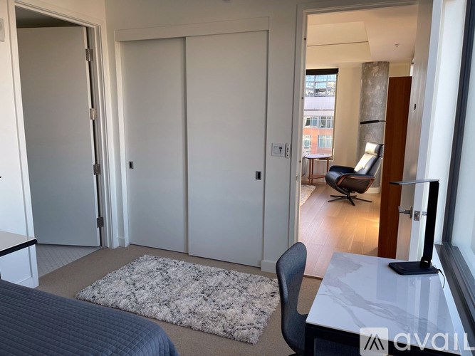 A room with a white table and a grey rug.