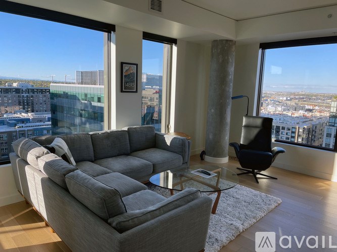 A living room with a grey sofa and a black chair.