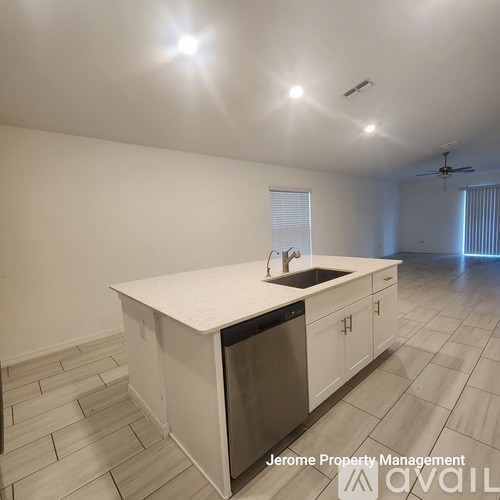 A kitchen with a white countertop and a stainless steel dishwasher.