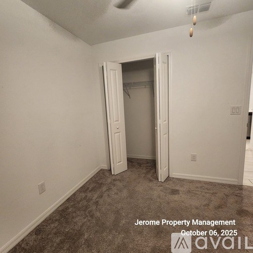 A room with a carpeted floor and a doorway leading to another room.