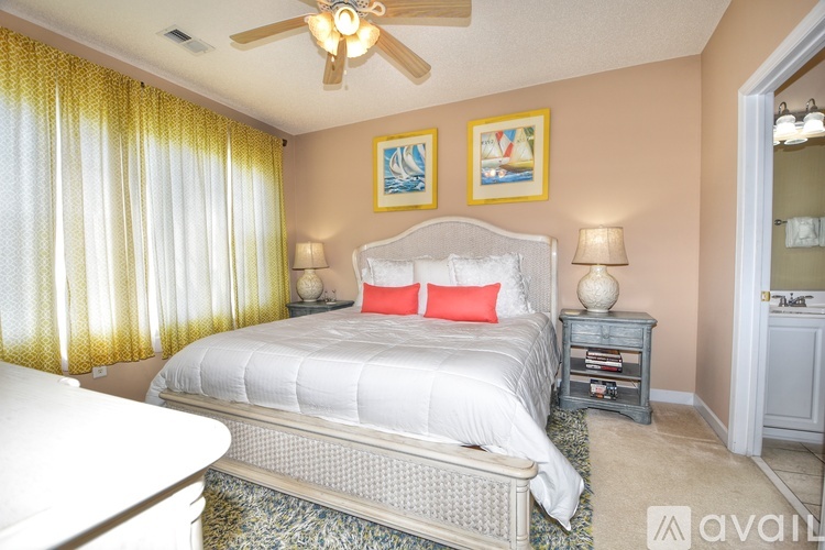 A bedroom with a bed, nightstand, and a ceiling fan.