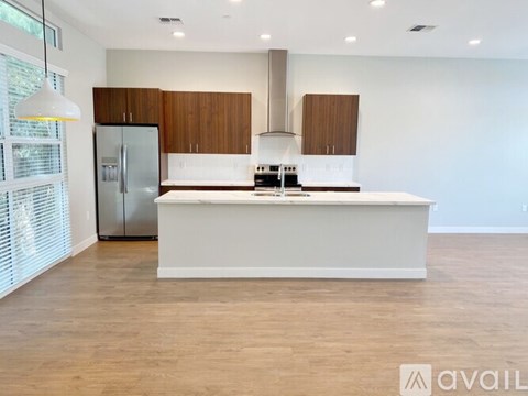 A modern kitchen with wooden cabinets and a white island.