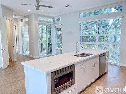 A modern kitchen with a large island and stainless steel appliances.