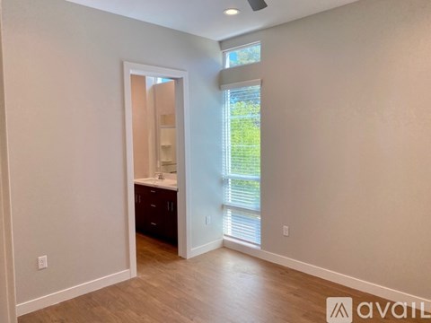 A room with a window and a door leading to another room.