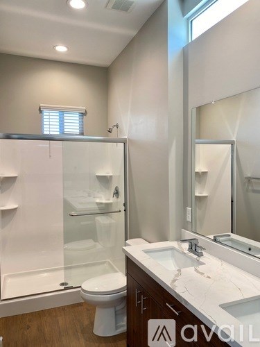 A bathroom with a toilet, sink, and shower.
