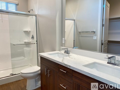 A bathroom with a toilet, sink, and mirror.