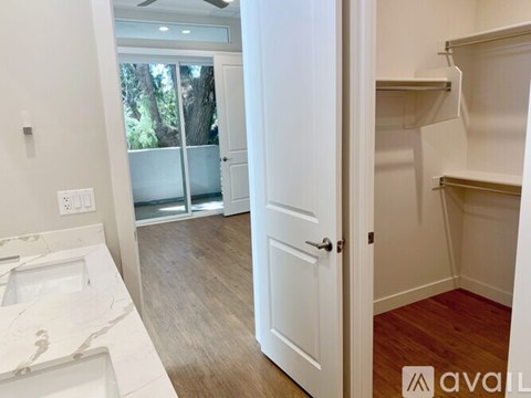 A bathroom with a marble sink and a door leading to a balcony.