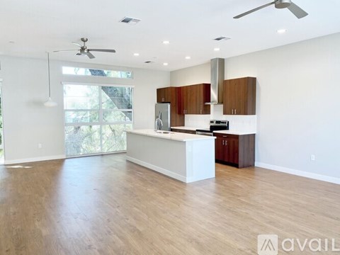 A spacious kitchen with wooden floors and a white island.