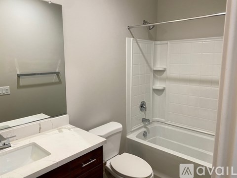 A white bathroom with a toilet, sink, and bathtub.