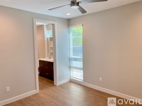 A room with a ceiling fan and a door leading to a bathroom.