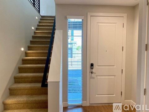 A staircase with a carpeted runner and a black handrail.