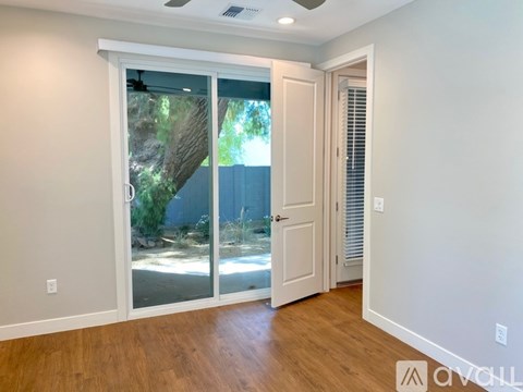 A room with a sliding glass door leading to a backyard.