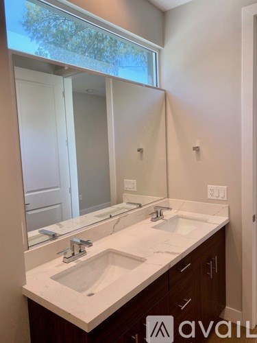 A bathroom with a double sink vanity and a large mirror.