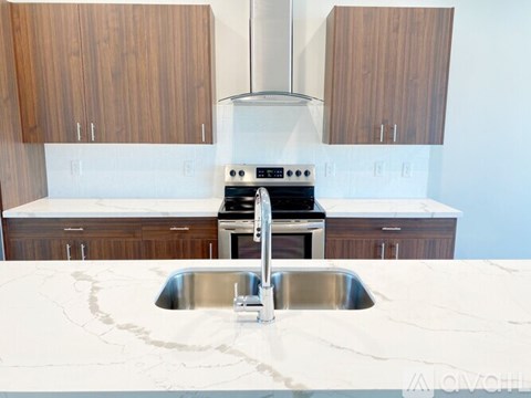 A modern kitchen with a white marble countertop and stainless steel appliances.