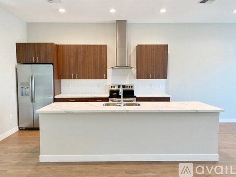 A kitchen with a white island and wooden cabinets.