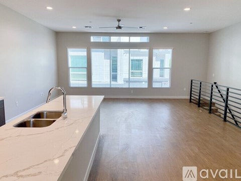 A spacious kitchen with a marble countertop and a window overlooking the city.