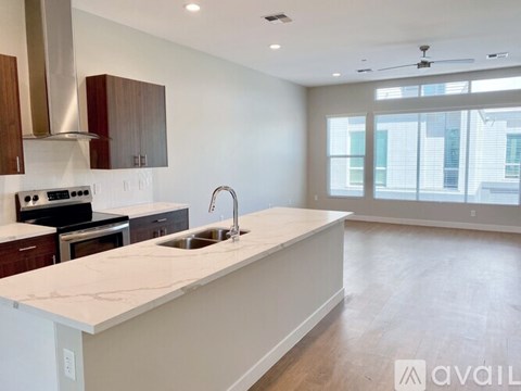 A modern kitchen with a marble countertop and stainless steel appliances.