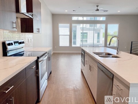 A modern kitchen with wooden cabinets and stainless steel appliances.