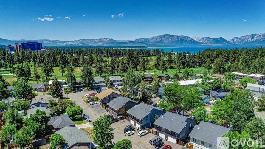 A bird's eye view of a residential area with houses and a mountain range in the background.