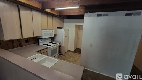 A kitchen with a white fridge and a white microwave.
