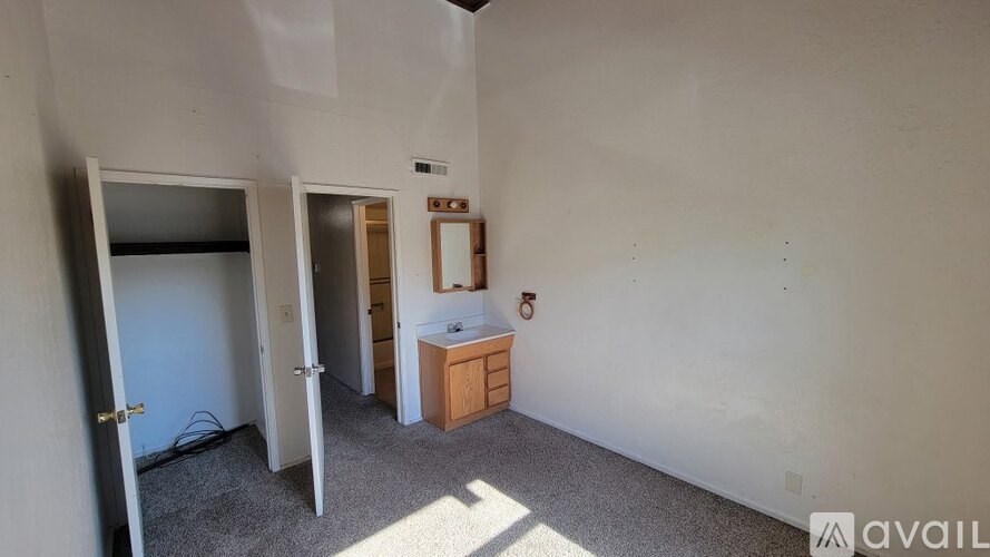 A room with a white wall and a wooden cabinet.