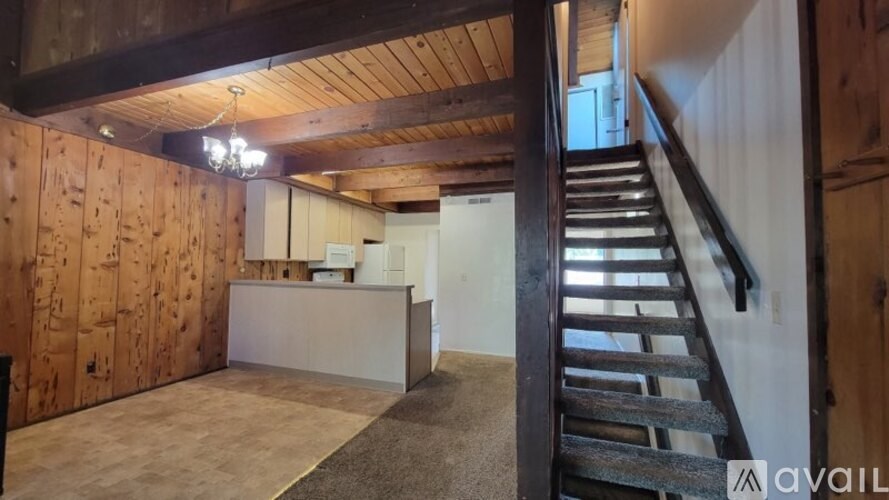 A wooden staircase leads up to a second floor with a reception area.