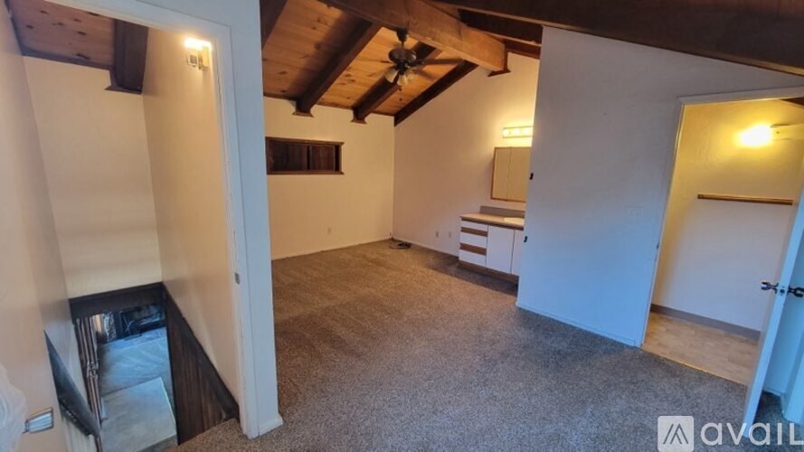 A room with a ceiling fan and a carpeted floor.