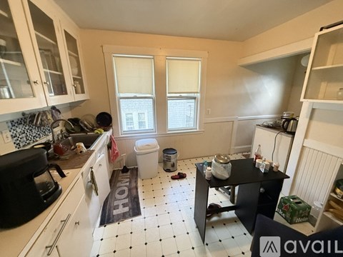 A kitchen with white cabinets and a black and white floor.