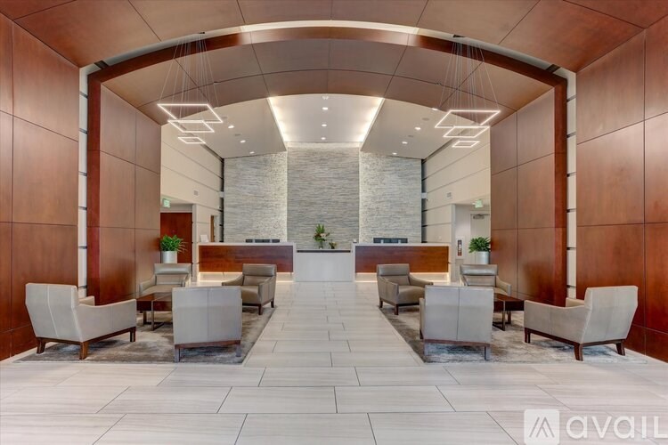 A spacious waiting area with white chairs and a stone wall in the background.